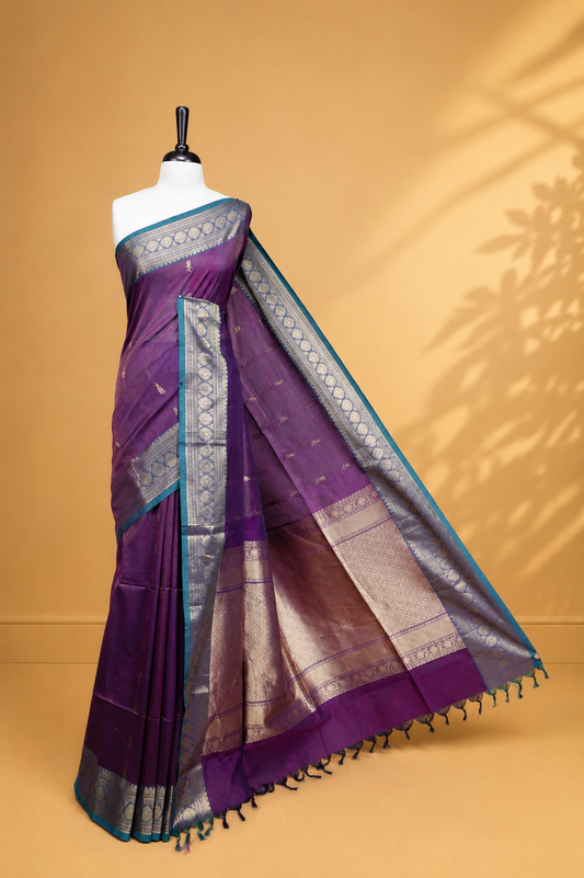 Purple colour chettinad cotton saree featuring gold zari stripes & motifs on body, complemented by Contrast Green colour with zari border, paired with matching blouse piece.