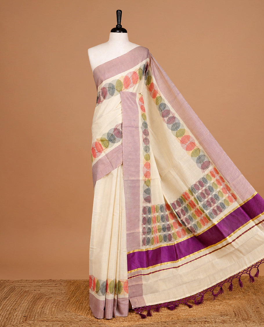Cream Colour Tissue Kerala Saree Featuring Multicolour Circular Prints Along The Border And Pallu, Complemented By A Violet Border With Traditional Gold Zari Accents, Paired With A Matching Blouse Piece.