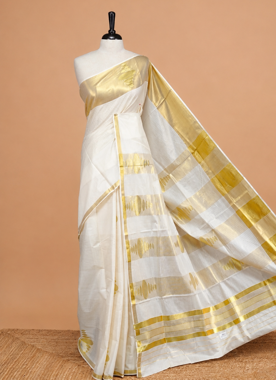 Cream Colour Cotton Kerala Saree Featuring Gold Strips  On The Body, Complemented By A  Gold Zari Circle Pattern On Border, Paired With A Matching Blouse Piece.