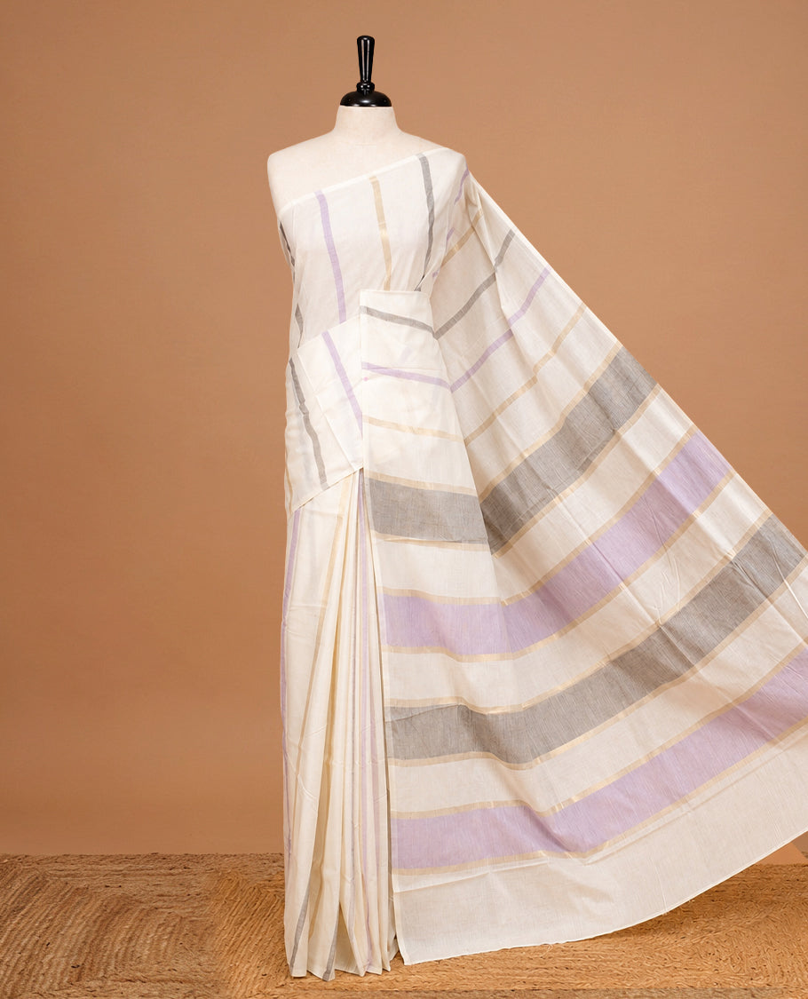 Off White Colour Cotton Kerala Saree Featuring Light Gold, Grey And Purple Zari Stripes On The Body, Enhanced By A Traditional Zari Border And Pallu, Paired With A Matching Blouse Piece.