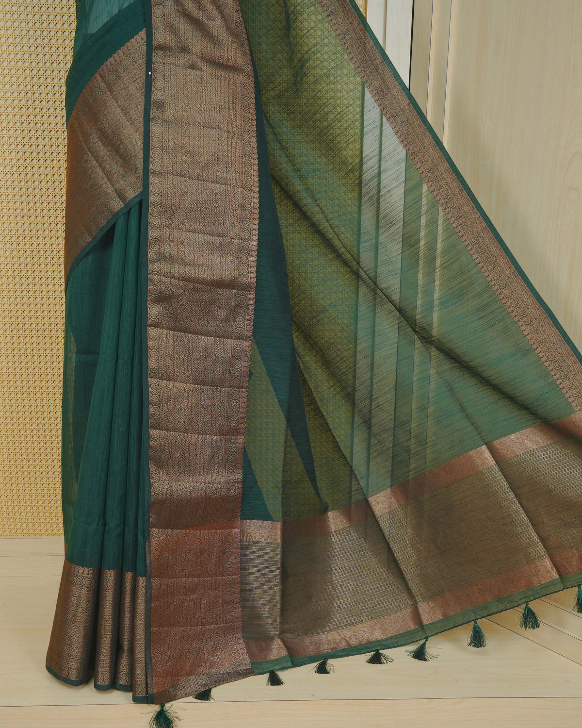Dark green colour semi linen saree plain body, contrast self colour gold zari detailed border, grand pallu comes with matching blouse piece