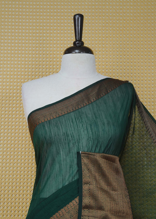 Dark green colour semi linen saree plain body, contrast self colour gold zari detailed border, grand pallu comes with matching blouse piece