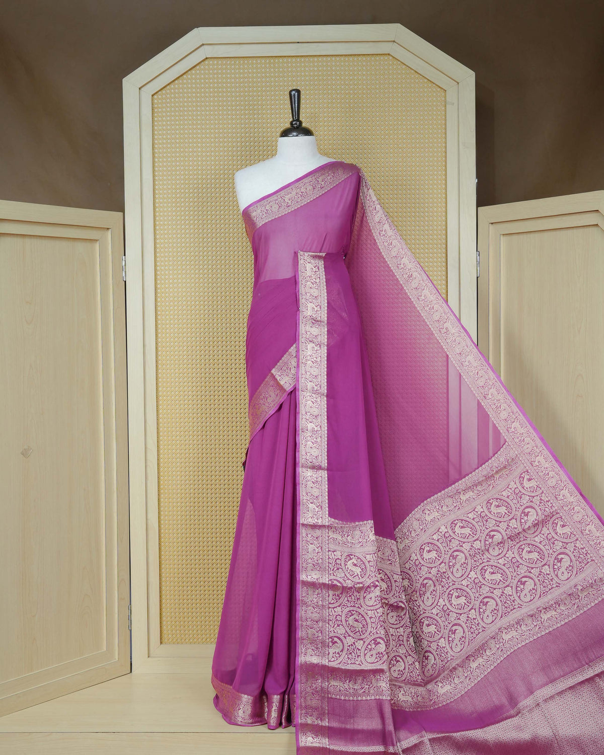 Plum colour georgette saree having plain body, peacock & deer gold zari detailed border, comes with matching blouse piece