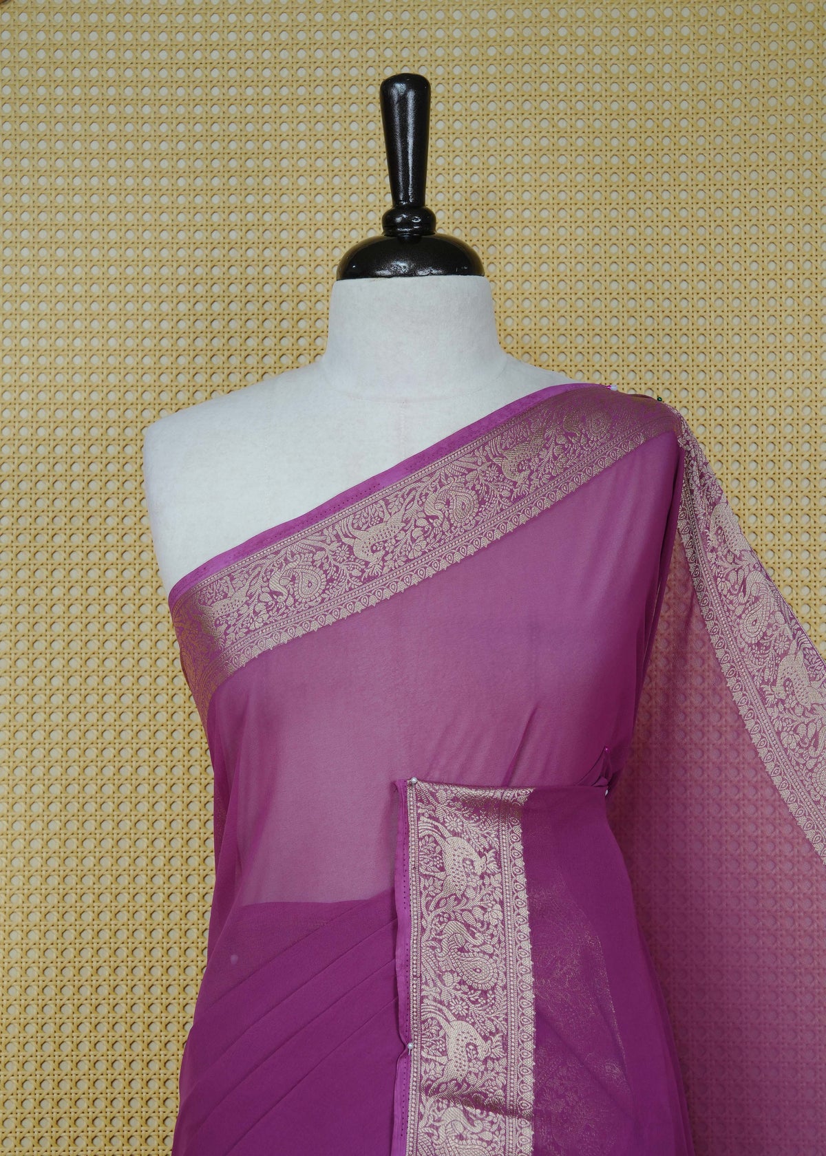 Plum colour georgette saree having plain body, peacock & deer gold zari detailed border, comes with matching blouse piece