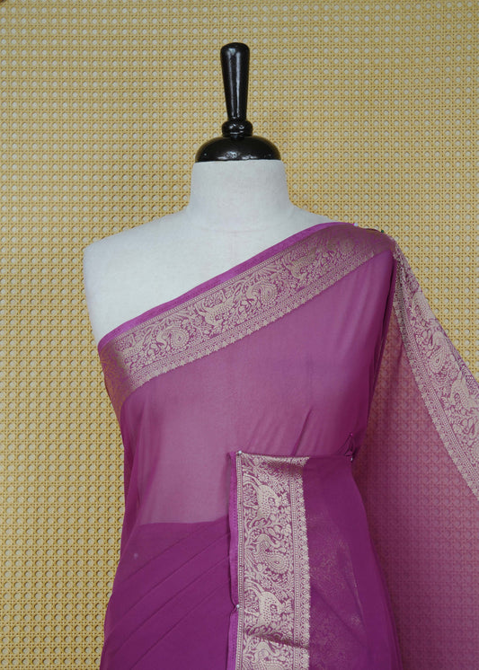 Plum colour georgette saree having plain body, peacock & deer gold zari detailed border, comes with matching blouse piece
