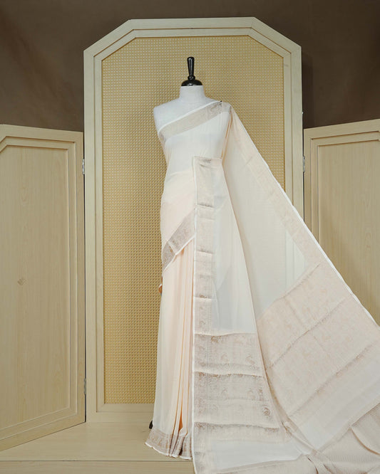 Cream colour georgette saree having plain body, peacock & deer gold zari detailed border, comes with matching blouse piece
