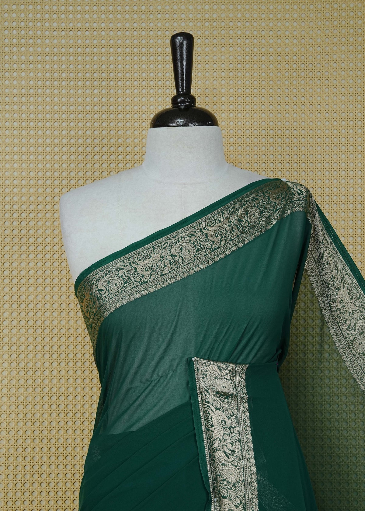 Bottle green colour georgette saree having plain body, peacock & deer gold zari detailed border, comes with matching blouse piece