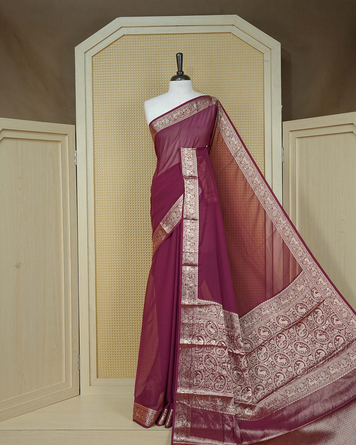 Wine colour georgette saree having plain body, peacock & deer gold zari detailed border, comes with matching blouse piece