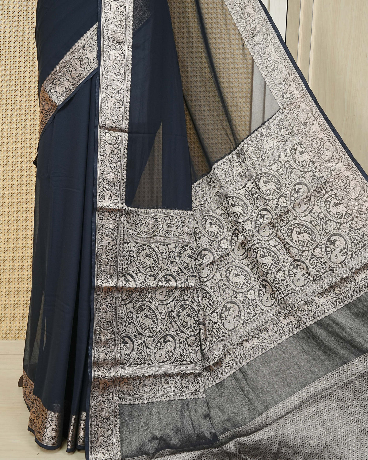 Black colour georgette saree having plain boy, Floral Gold zari detailed pattern border, comes with matching blouse piece