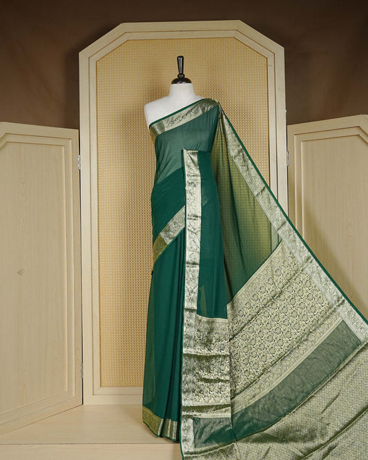 Bottle green colour georgette saree having plain boy, Floral Gold zari detailed pattern border, comes with matching blouse piece