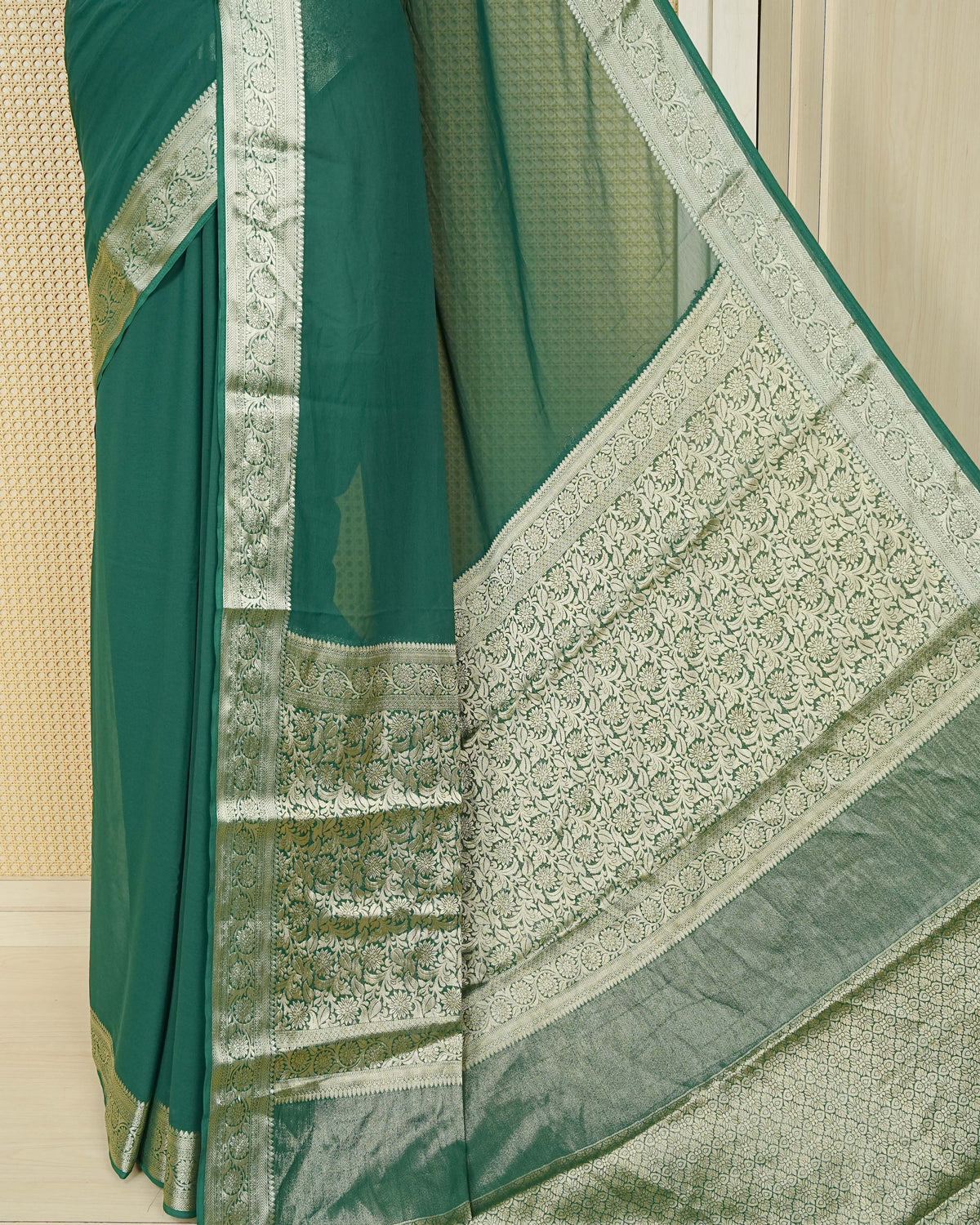 Bottle green colour georgette saree having plain boy, Floral Gold zari detailed pattern border, comes with matching blouse piece