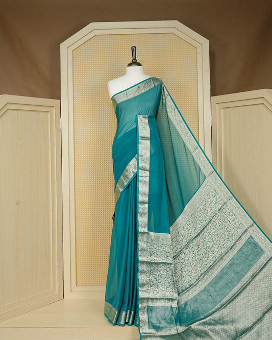 Teal green colour georgette saree having plain boy, Floral Gold zari detailed pattern border, comes with matching blouse piece