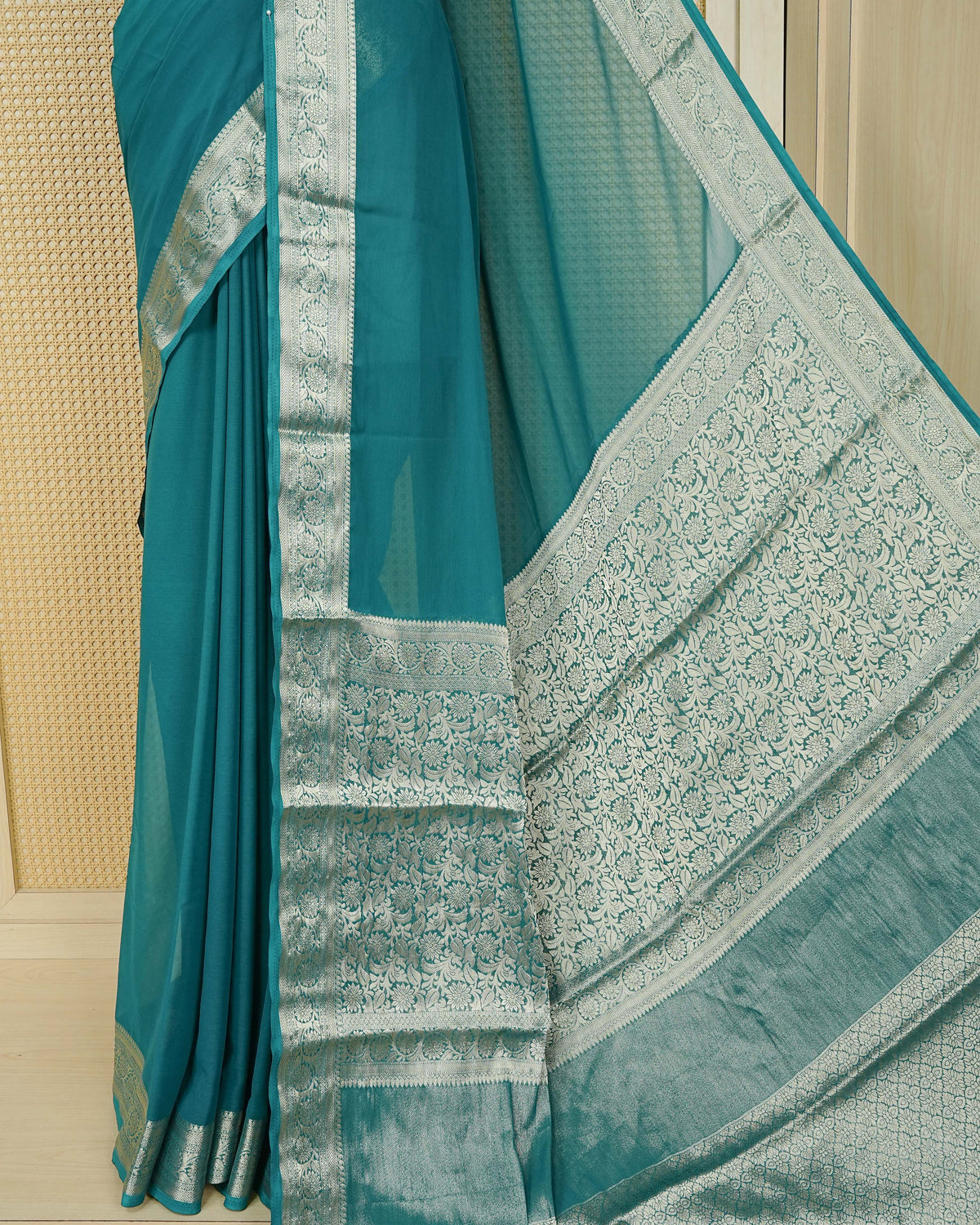 Teal green colour georgette saree having plain boy, Floral Gold zari detailed pattern border, comes with matching blouse piece