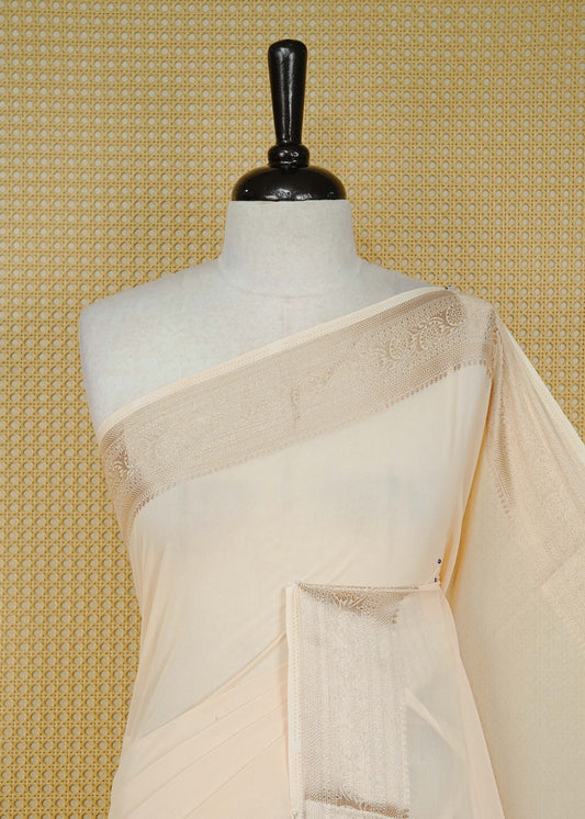 Cream colour georgette saree having plain boy, Floral Gold zari detailed pattern border, comes with matching blouse piece