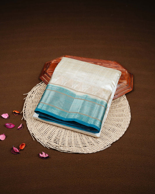 Cream colour Tussar silk saree Featuring Plain body, complemented by Contrast teal green colour gold zari temple & zari border, paired with matching blouse piece.