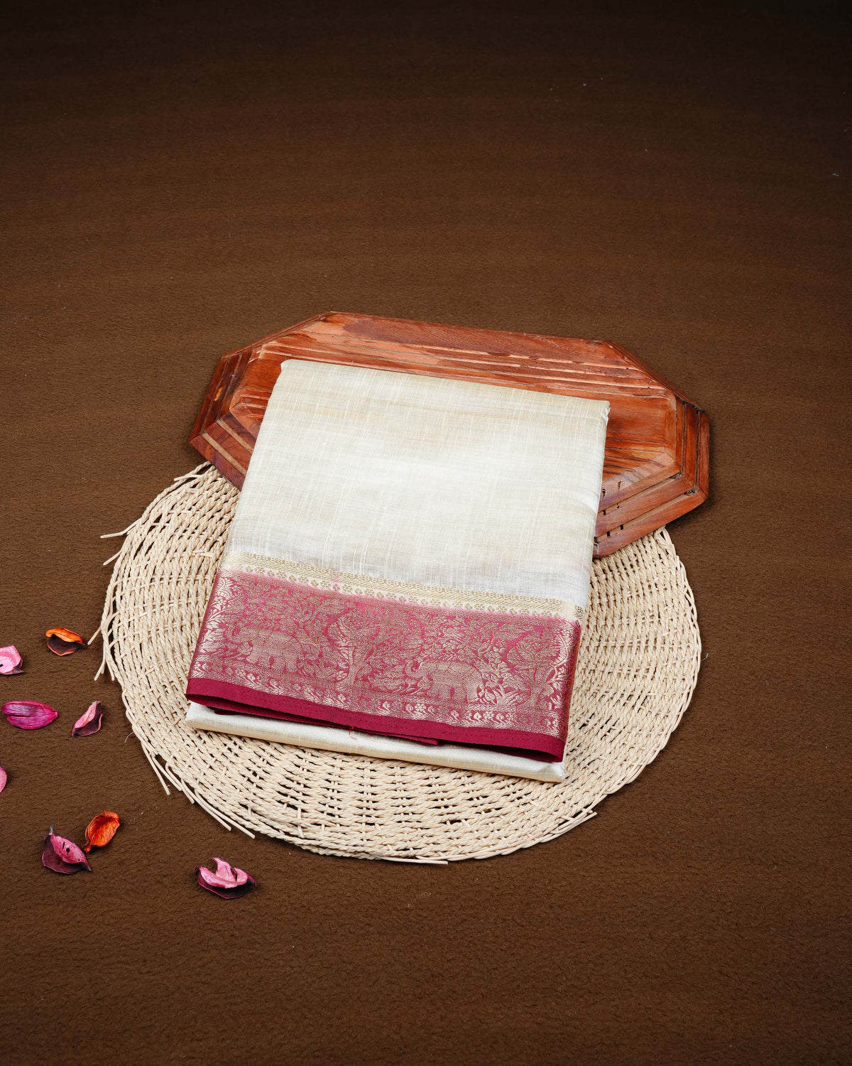 Cream colour Tussar silk saree Featuring Plain body, complemented by Contrast dark maroon colour gold zari elephant & tree motifs on border, paired with matching blouse piece.
