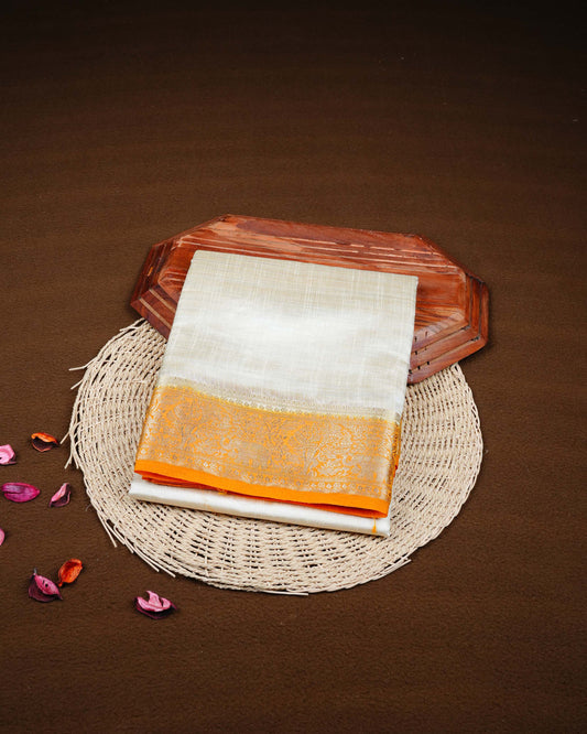 Cream colour Tussar silk saree Featuring Plain body, complemented by Contrast orange colour gold zari elephant & tree motifs on border, paired with matching blouse piece.