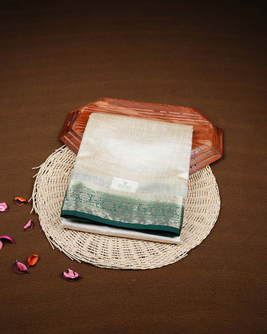 Cream colour Tussar silk saree Featuring Plain body, complemented by Contrast dark green colour gold zari floral patterns on border, paired with matching blouse piece.
