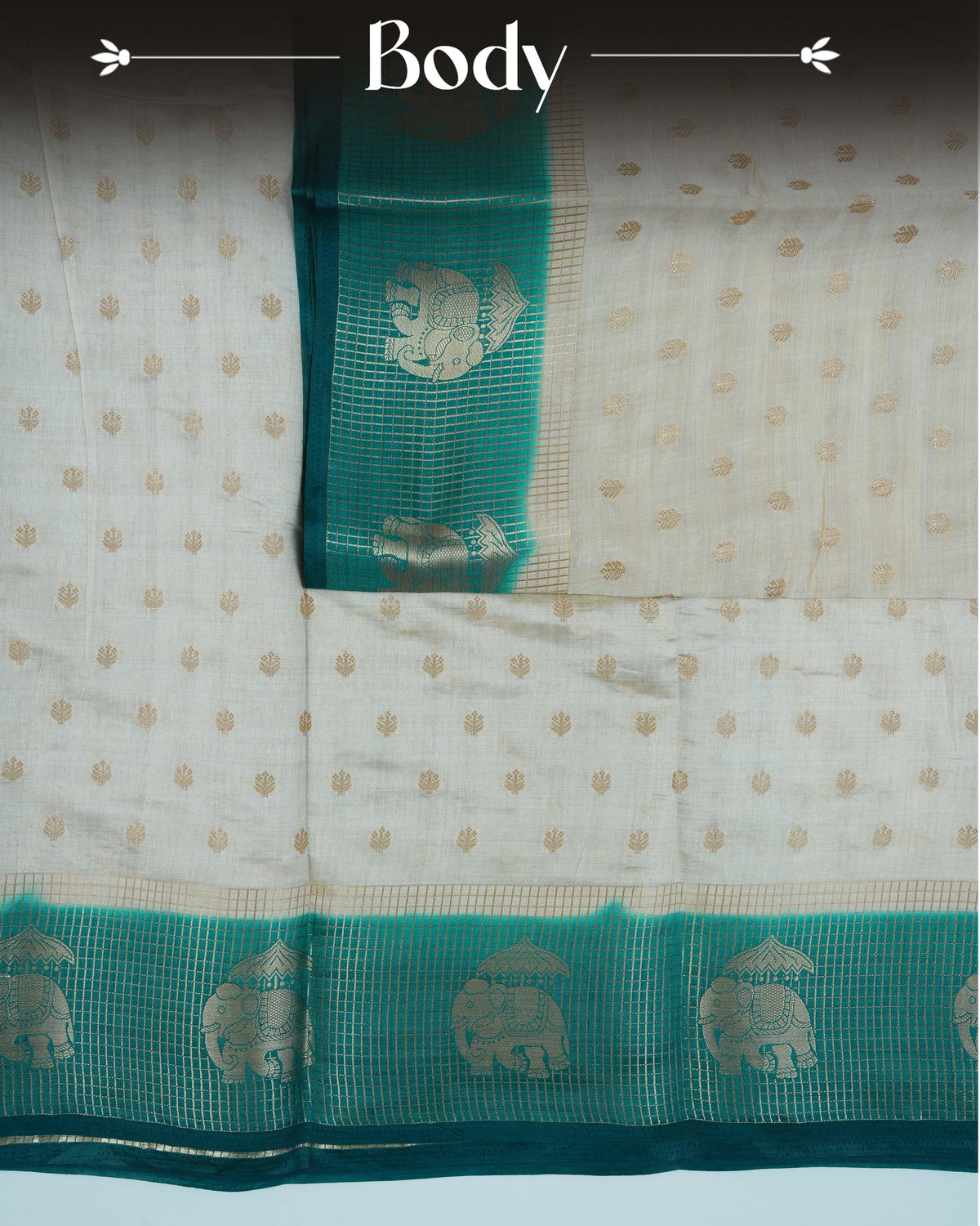 Cream colour Tussar silk saree Featuring buttas on body, complemented by Contrast bottle green colour gold zari check pattern with elephant motifs on border, paired with matching blouse piece.