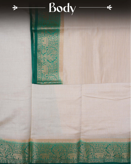 Cream colour Tussar silk saree Featuring Plain body, complemented by Contrast green colour gold zari elephant & tree motifs on border, paired with matching blouse piece.