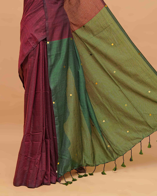Maroon and Green coloured half and half mul cotton saree featuring elegant sequin detailing on the body, finished with a beautiful pallu adorned with tassels.