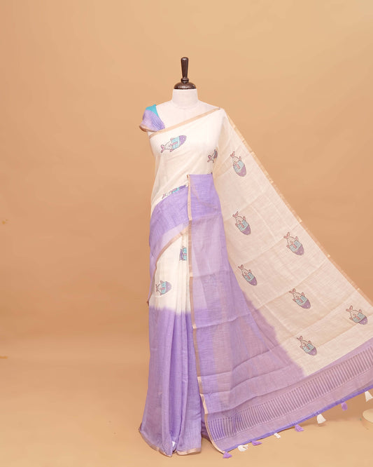 Off white and purple colour semi linen saree featuring adorable fish prints on the body, a delicate tissue border, and a pallu adorned with tassels, Comes with a matching blouse piece.