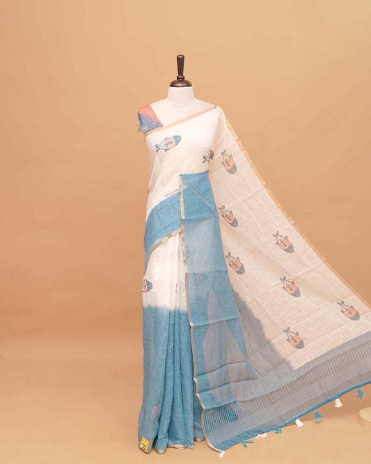Off white and Teal colour semi linen saree featuring adorable fish prints on the body, a delicate tissue border, and a pallu adorned with tassels, Comes with a matching blouse piece.