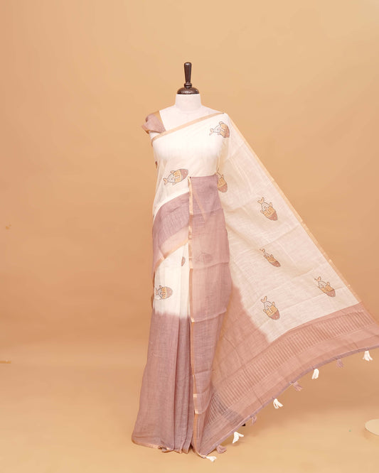 Off white and Light Brown colour semi linen saree featuring adorable fish prints on the body, a delicate tissue border, and a pallu adorned with tassels, Comes with a matching blouse piece.