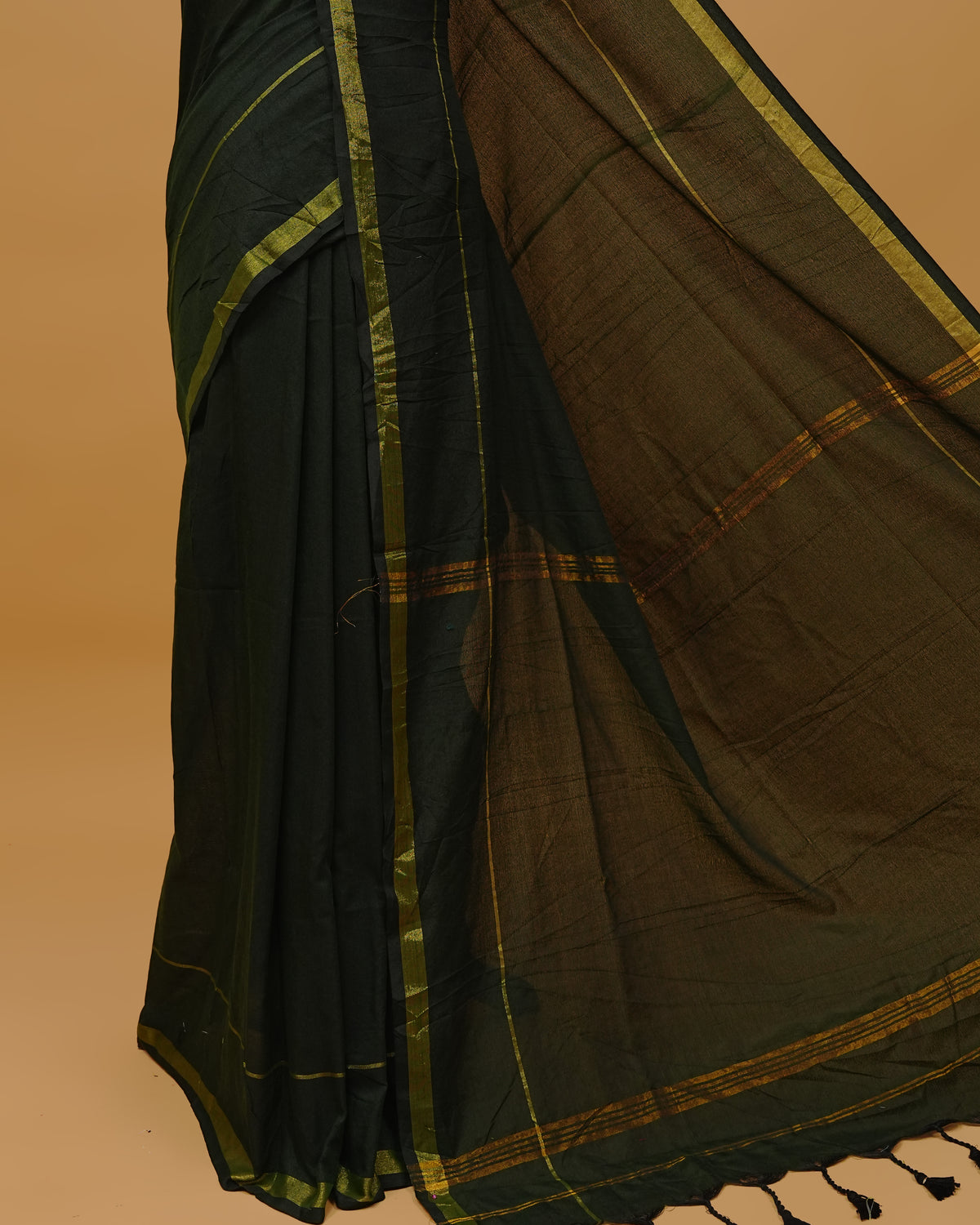 Dark Green Colour Mul Cotton Saree Featuring Plain body. Gold zari Border & Golden Strips on pallu comes With Tassels