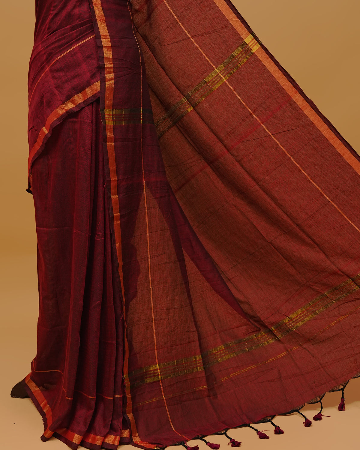 Maroon Colour Mul Cotton Saree Featuring Plain body. Gold zari Border & Golden Strips on pallu comes With Tassels