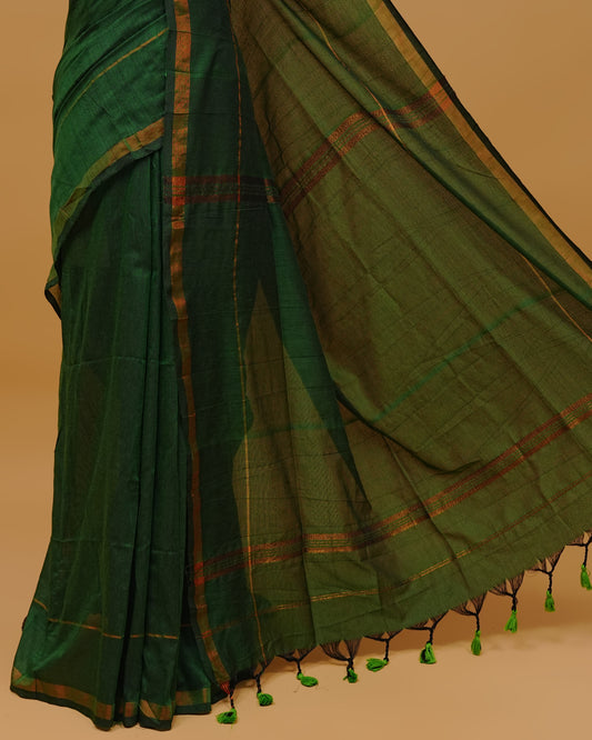 Bottle Green Colour Mul Cotton Saree Featuring Plain body. Copper zari Border & Copper zari Strips on pallu comes With Tassels