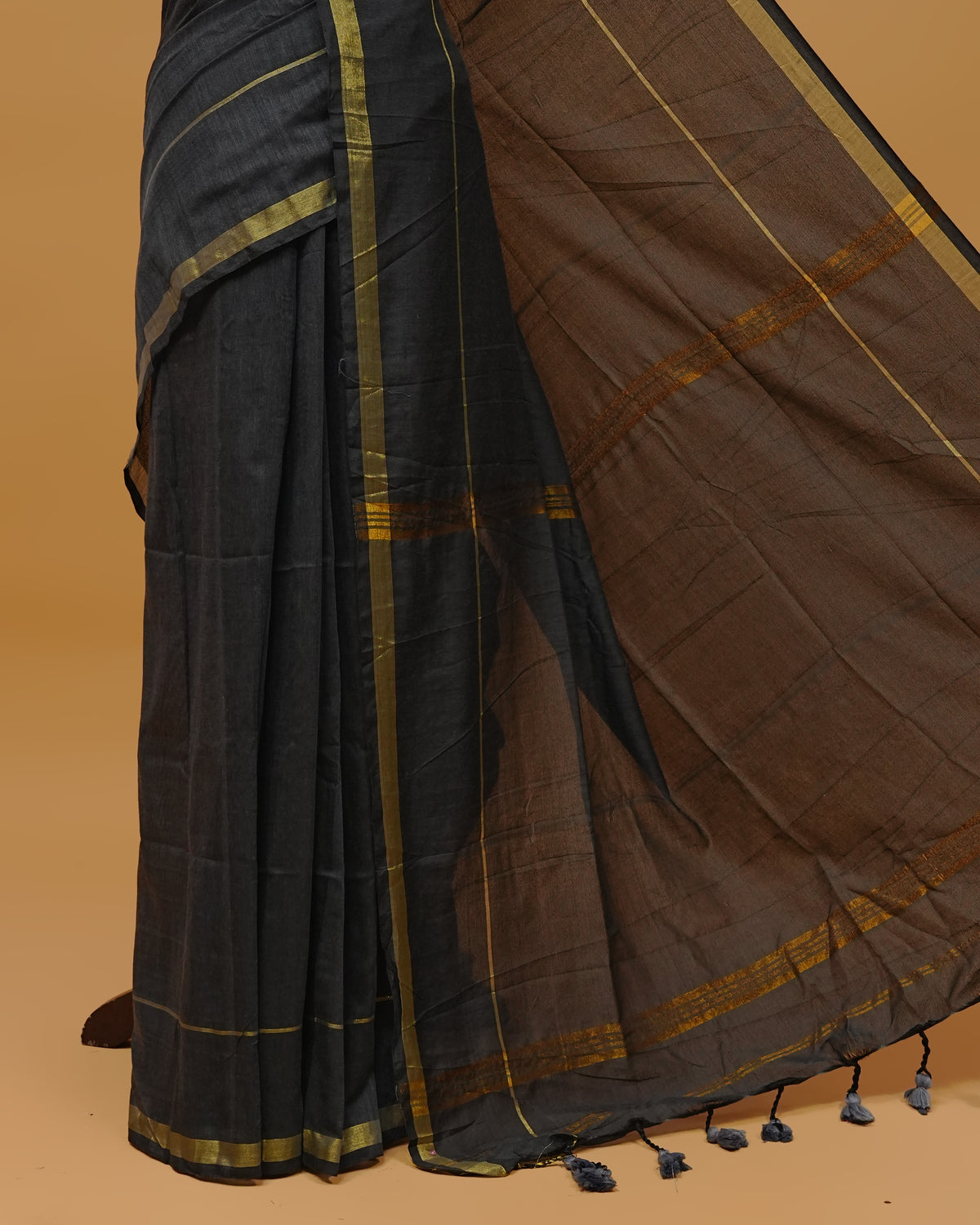 Greyish Black  Colour Mul Cotton Saree Featuring Plain body. Gold zari Border & Golden Strips on pallu comes With Tassels