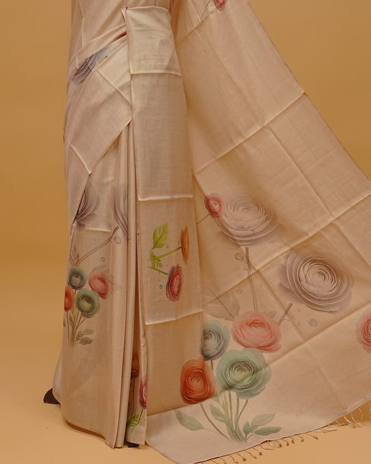 Cream colour Semi Tissue saree featuring Floral Motifs on body, a Gold Simple border, a pallu finished with tassels, paired with a matching blouse piece.