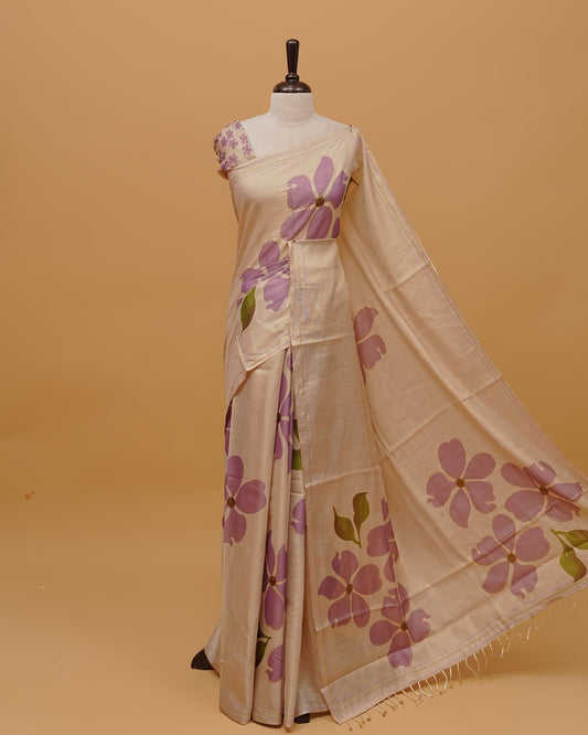 Cream colour Semi Tissue saree featuring  Lavender colour Floral Motifs on body, a Threaded border & pallu finished with tassels, paired with a matching blouse piece.