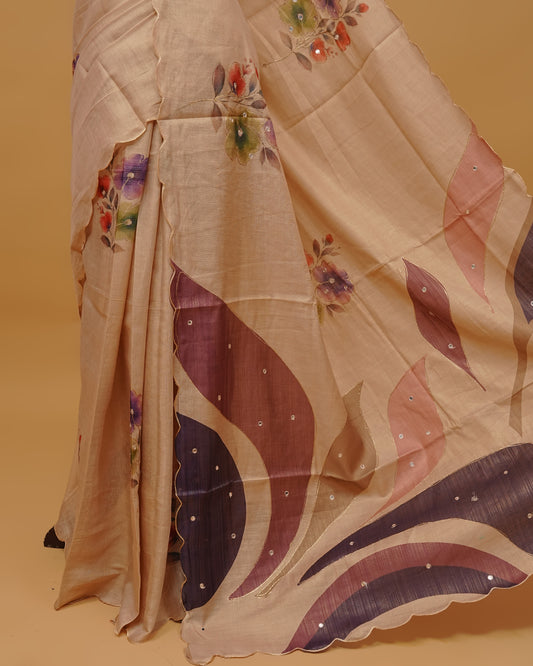 Cream colour Semi Tissue saree featuring Floral Motifs Design and Mirror Work on the body, a Scallop border, and a pallu finished with tassels, paired with a matching blouse piece.