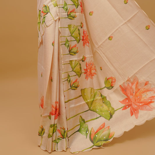 Cream colour semi tissue saree featuring Floral prints with Mirror Work on the body, with scallop border & pallu finished with tassels. Paired with a matching blouse piece.