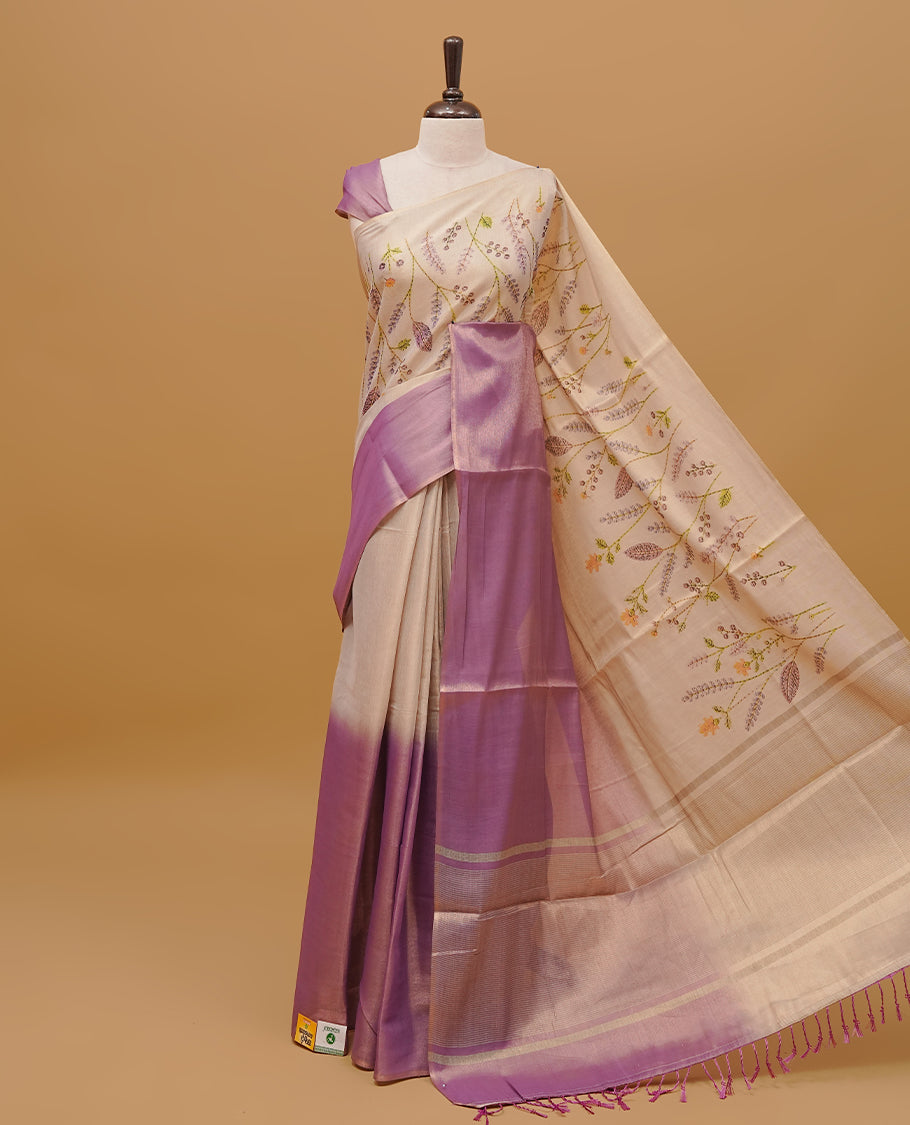 Purple and cream colour half an half semi tissue saree featuring a floral prints on body, without border & pallu finished with tassels. Paired with a matching blouse piece.
