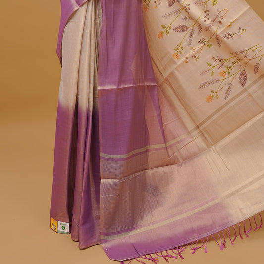 Purple and cream colour half an half semi tissue saree featuring a floral prints on body, without border & pallu finished with tassels. Paired with a matching blouse piece.