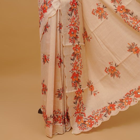 Cream colour semi tissue saree featuring floral prints with Mirror Work on body, with scallop border & pallu finished with tassels. Paired with a matching blouse piece.