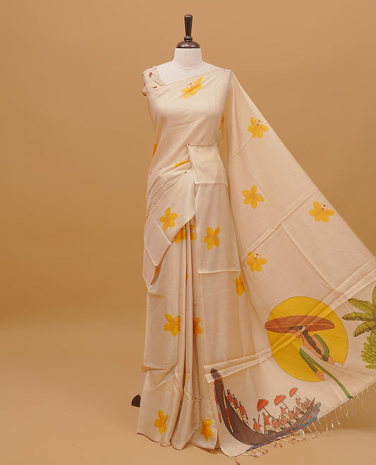 Cream colour semi tissue saree featuring yellow floral prints on the body, without border &  Traditional festival printed pallu finished with tassels. Paired with a matching blouse piece.