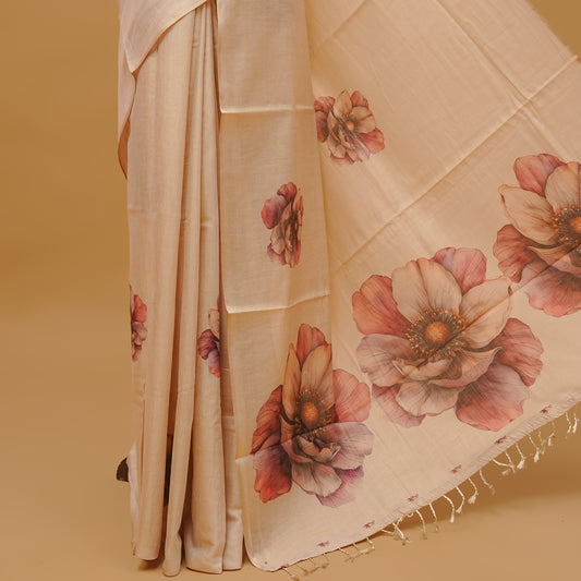Cream colour semi tissue saree featuring floral prints on body, a borderless design & pallu finished with tassels. Paired with a matching blouse piece.