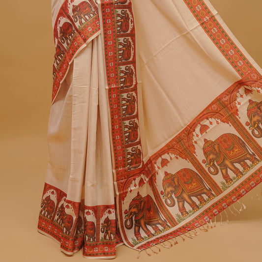 Cream colour semi tissue saree featuring a plain body, Elephant prints on Border & pallu finished with tassels. Paired with a matching blouse piece.