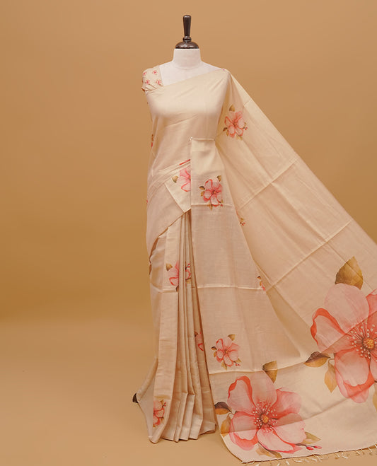 Cream colour semi tissue saree featuring floral prints on body, borderless design & pallu finished with tassels. Paired with a matching blouse piece.
