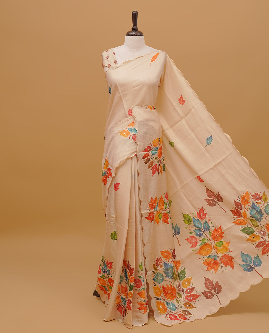 Cream colour semi tissue saree featuring Flowers prints and Mirror Work on the body, with scallop border & pallu finished with tassels. Paired with a matching blouse piece.