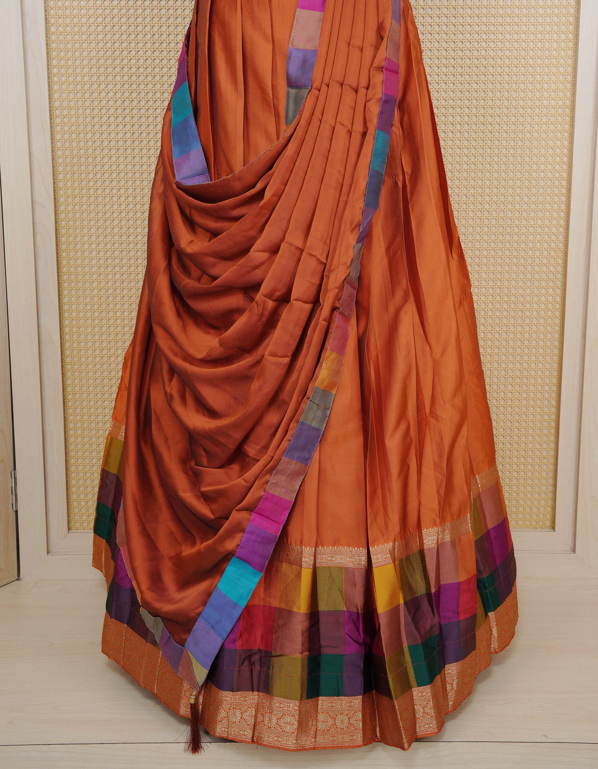 Rust Orange colour Semi Silk Semi stitched dhavani set featuring a Plain body with a matching Multi colour with gold zari bordered skirt & blouse piece and dupatta.
