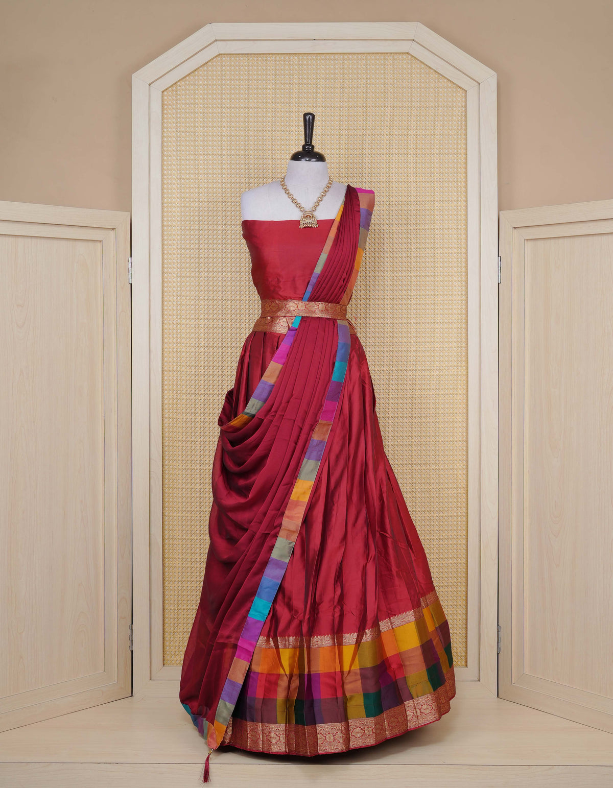 Maroon colour Semi Silk Semi stitched dhavani set featuring a Plain body with a matching Multi colour with gold zari bordered skirt & blouse piece and dupatta.