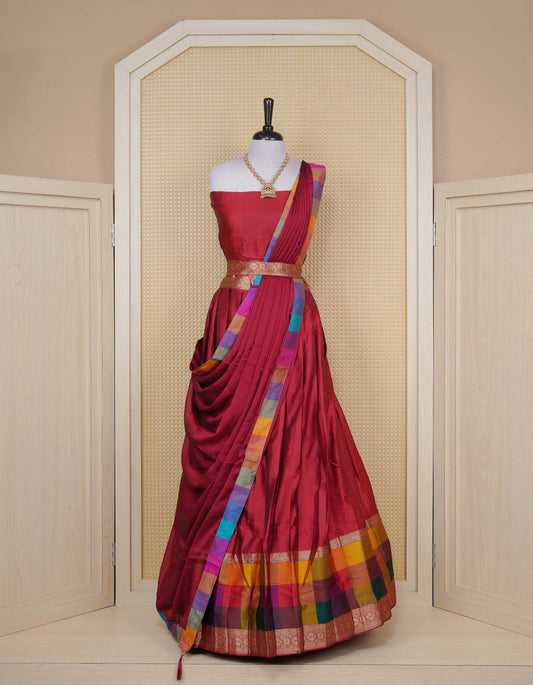 Maroon colour Semi Silk Semi stitched dhavani set featuring a Plain body with a matching Multi colour with gold zari bordered skirt & blouse piece and dupatta.