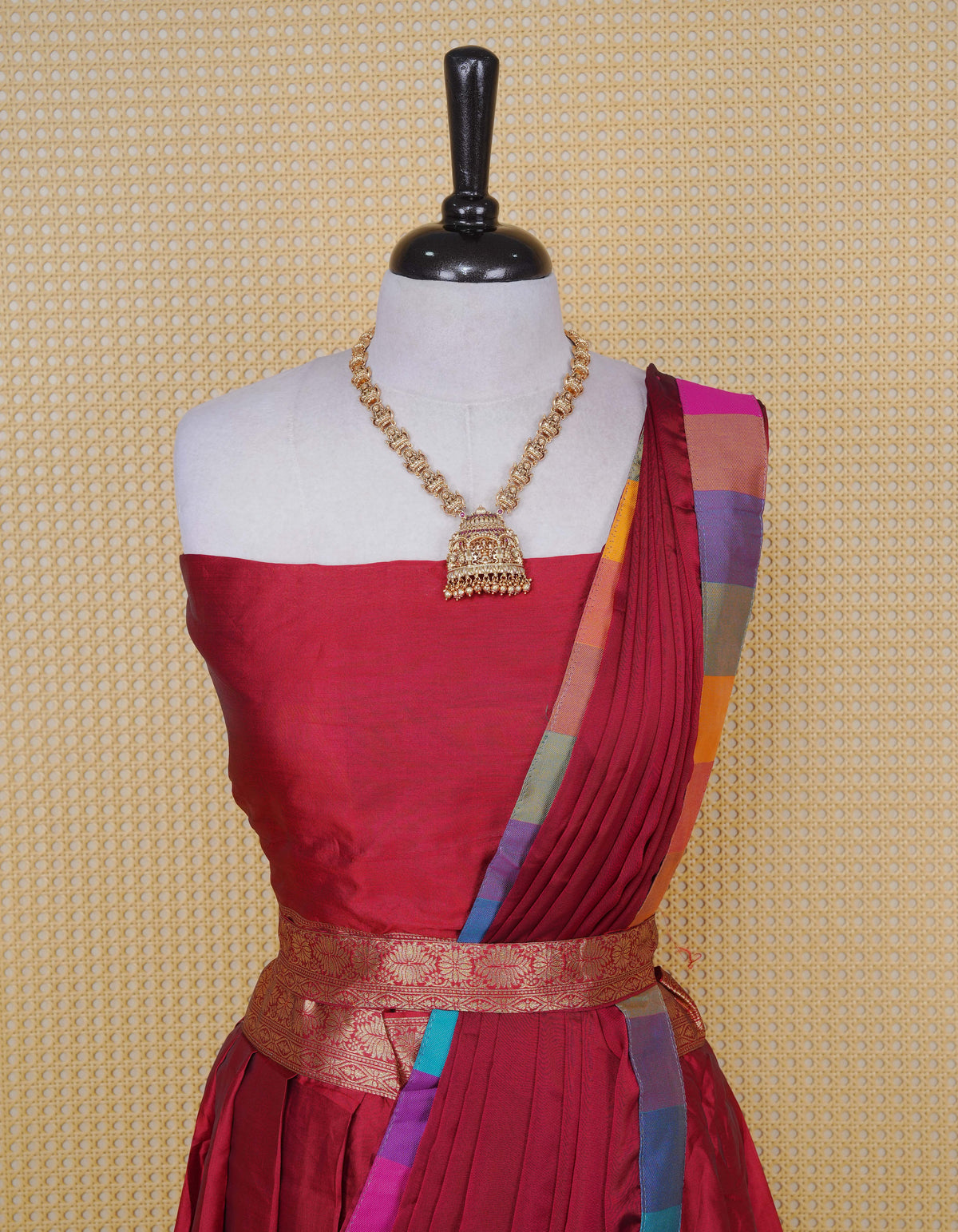 Maroon colour Semi Silk Semi stitched dhavani set featuring a Plain body with a matching Multi colour with gold zari bordered skirt & blouse piece and dupatta.