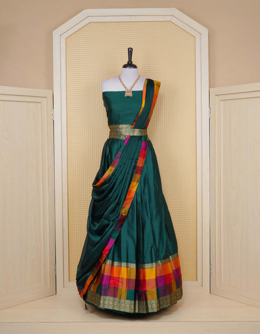 Bottle green colour Semi Silk Semi stitched dhavani set featuring a Plain body with a matching Multi colour with gold zari bordered skirt & blouse piece and dupatta.