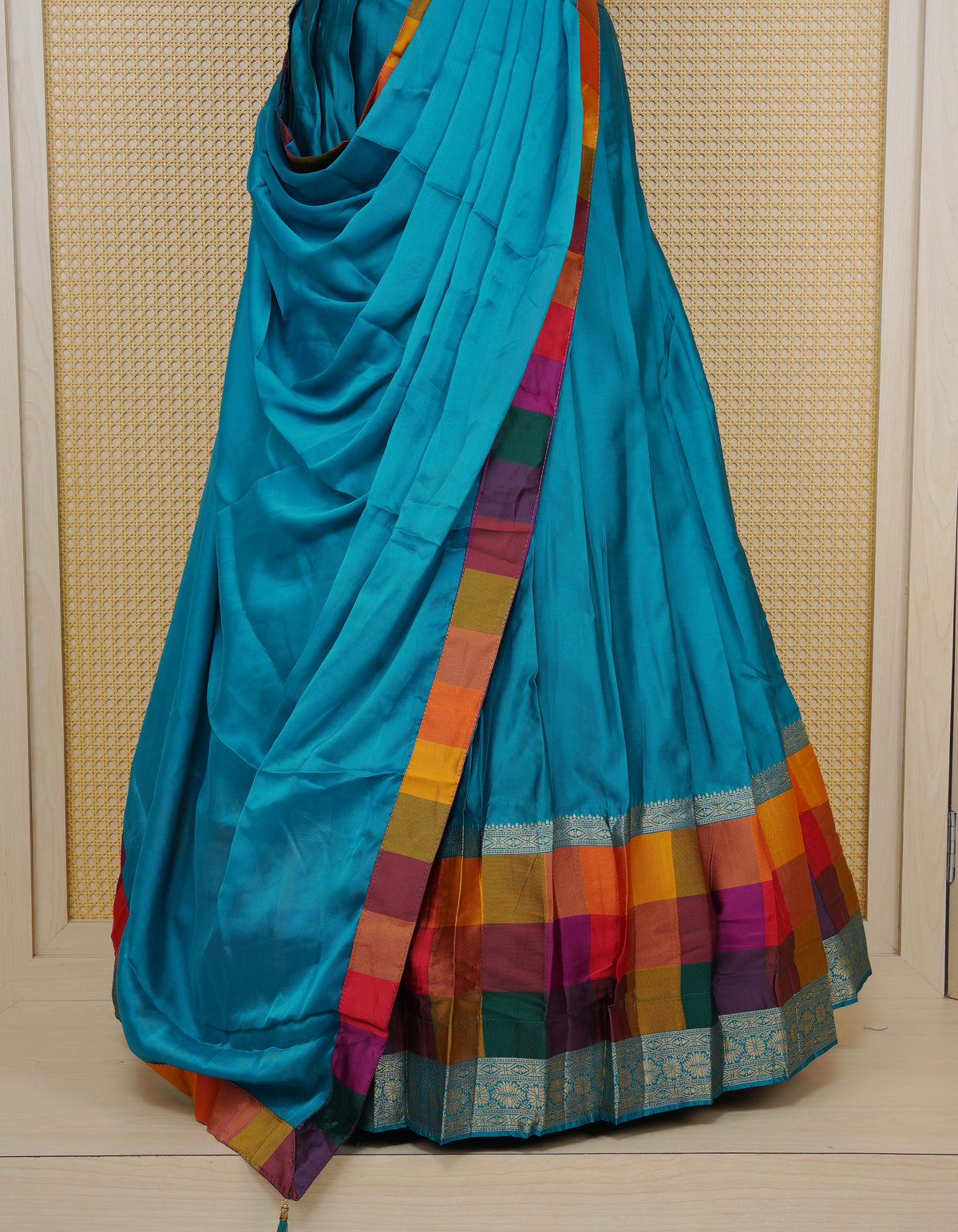 Peacock Green colour Semi Silk Semi stitched dhavani set featuring a Plain body with a matching Multi colour with gold zari bordered skirt & blouse piece and dupatta.